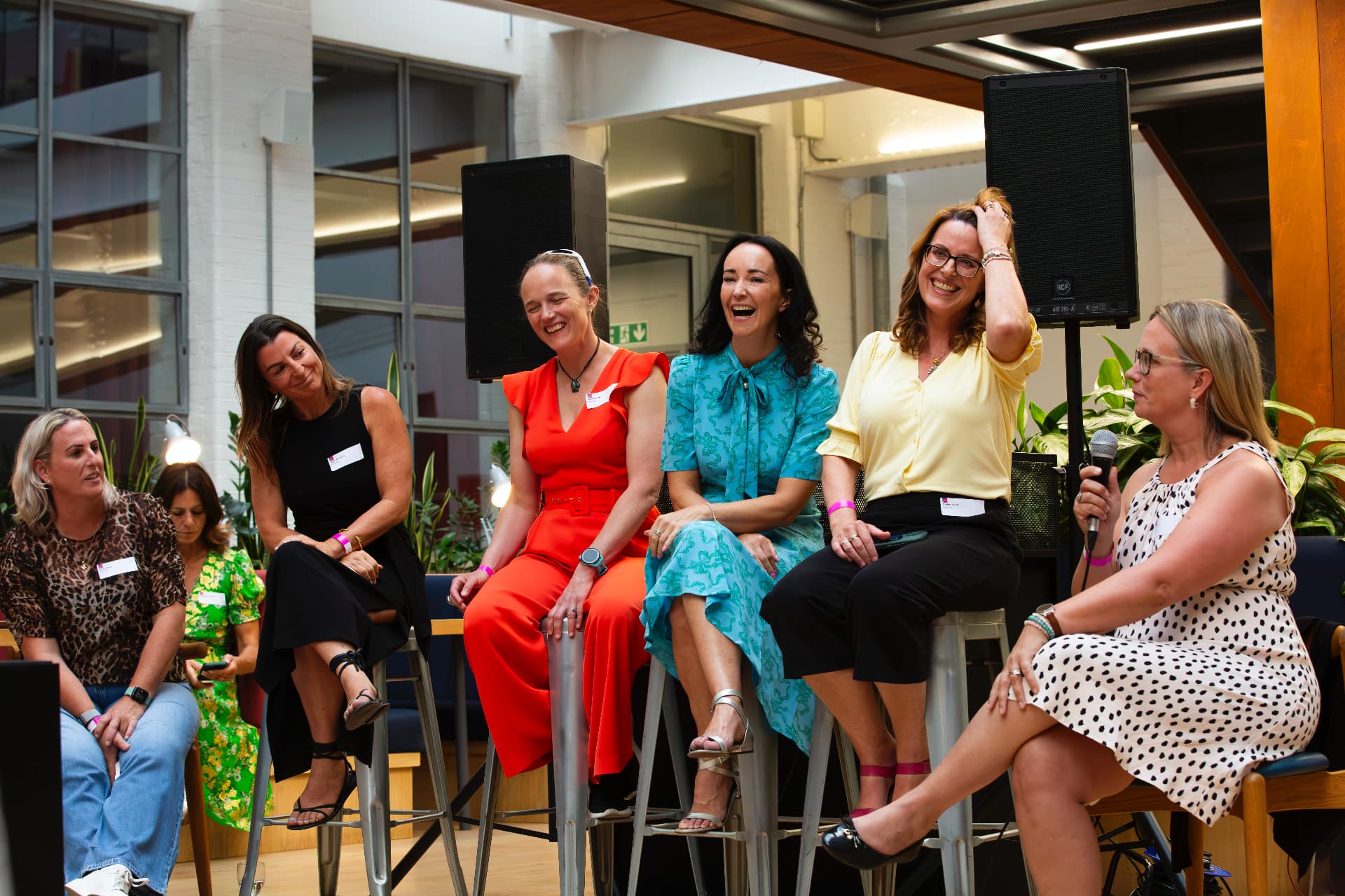 Panel of women laughing together at an EmpowerHER event